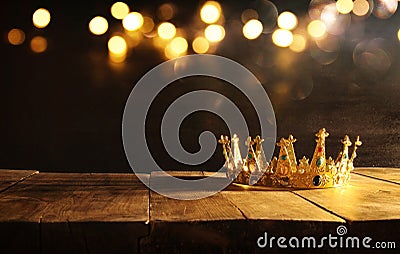 low key of queen/king crown over wooden table. vintage filtered. fantasy medieval period Stock Photo