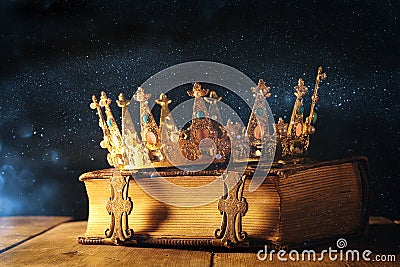 low key of queen/king crown on old book. vintage filtered. fantasy medieval period Stock Photo