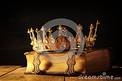 low key of queen/king crown on old book. vintage filtered. fantasy medieval period Stock Photo