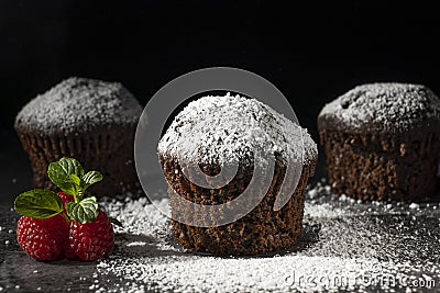 Low key shot of chocolate muffins sprinkled with powdered sugar Stock Photo