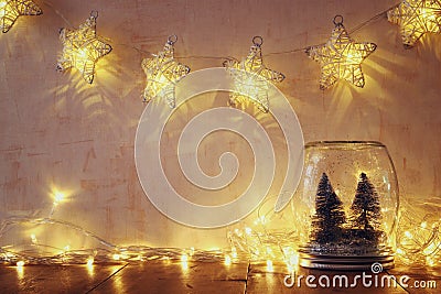Low key and vintage filtered image of christmas trees in mason jar with garland warm lights Stock Photo
