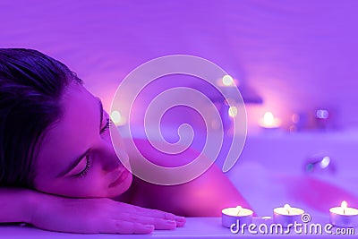 Low light face shot of woman in foam bath. Stock Photo
