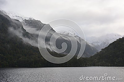 Low lying clouds across the mountains at Lake Manapouri in New Zealand Stock Photo