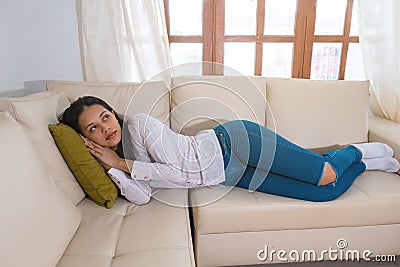 Low power. Photo of a young woman, who is lying on the couch while feeling feverish Stock Photo