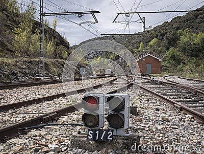 Low railway exit signal next to the track rails giving the red indication (stop announcement) Stock Photo
