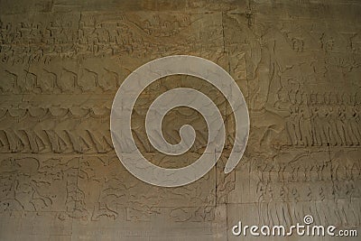 The low relief sandstone carvings tell the story of Hindu Brahmin beliefs between angels and devils on the walls of Angkor Wat Stock Photo