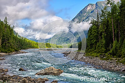 Low scattered clouds over a tumultuous small river Stock Photo