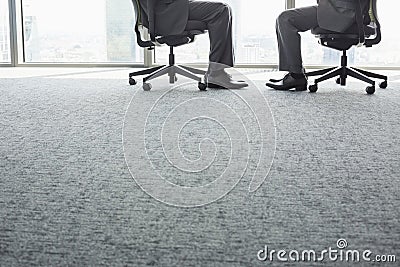 Low section of businessmen sitting on office chairs Stock Photo