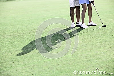 Low section of couple playing golf at course Editorial Stock Photo