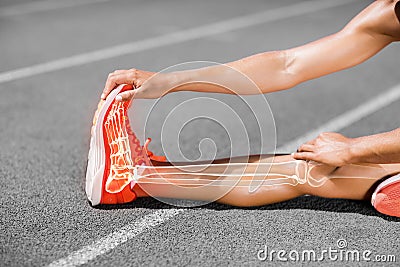 Low section of female athlete stretching on sports track Stock Photo