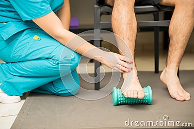 Therapist Assisting Patient To Use Foot Roller For Plantar Fasciitis Stock Photo