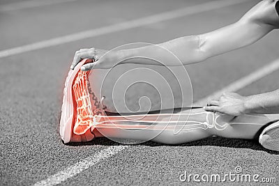 Low section of sportswoman stretching on sports track Stock Photo