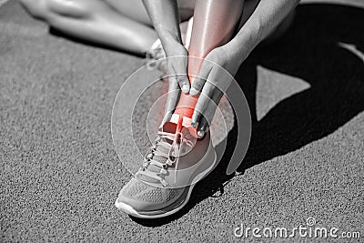 Low section of sportswoman suffering from joint pain on track Stock Photo