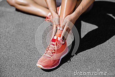 Low section of sportswoman suffering from pain on track Stock Photo