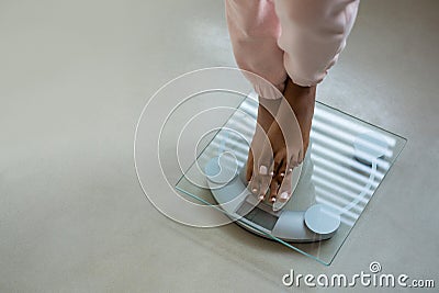 Low section of woman standing on bathroom scale Stock Photo