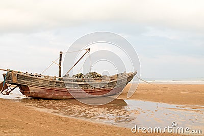 Beached fishing boat at low tide Stock Photo