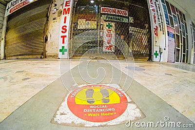 Low wideangle shot of floor markings for social distancing in front of a closed chemist shop as the new wave of Editorial Stock Photo