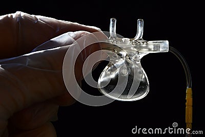 Lower side of capnography sidestream nose and mouth element held in doctor left hand in latex glove Stock Photo