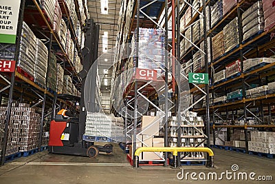 Lowering stock in a distribution warehouse using aisle truck Stock Photo