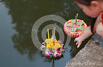 Loy Krathong festival, Asian Child girl floating krathong in pond for forgiveness Goddess Ganges to celebrate festival in Thailand Stock Photo