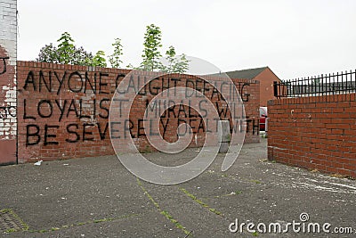 Loyalist warning message on a brick wall, Belfast. Editorial Stock Photo