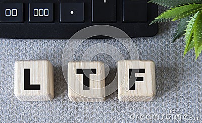 LTF - acronym on wooden cubes on a gray background with a calculator Stock Photo