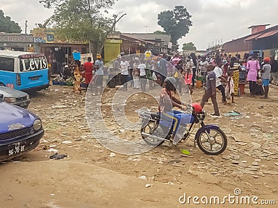 View of slum with a exterior market in the Luanda city downtown center with clay road, people, vehicles and buildings Editorial Stock Photo