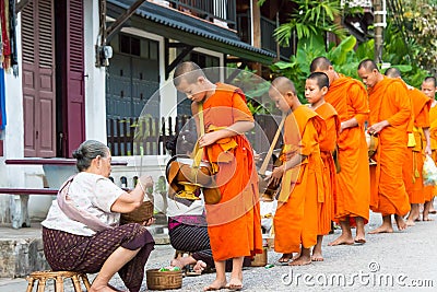 Buddhist monks collecting alms in the morning in Luang Prabang, Laos. Editorial Stock Photo
