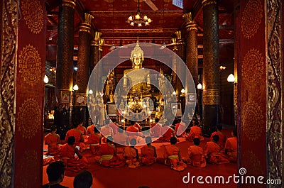 LUANG PRABANG, LAOS - MARCH 20 2018: Group of monks pray in Wat May Suwannaphumaham Temple in Laos Editorial Stock Photo