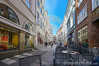 Lubeck, Germany, April 17, 2023: Narrow pedestrian zone with shops and street cafes in the historic old town of the hanseatic city Editorial Stock Photo