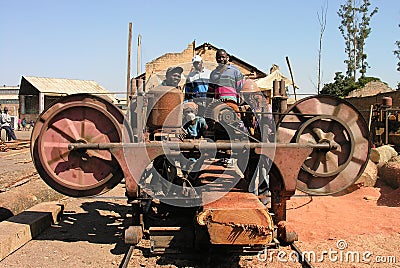 Lubumbashi, Democratic Republic of Congo, 21st June 2005: Group of carpenters posing for the camera while operating a timber saw Editorial Stock Photo