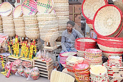 A tribal man is selling a variety of traditional wooden toys and bamboo baskets. Editorial Stock Photo
