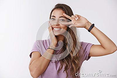 Lucky charismatic energized cute woman posing showing victory peace gesture near eye touching cheek feeling relieved Stock Photo