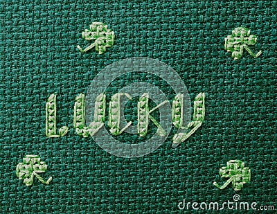 Lucky cross stitched in green on green Stock Photo