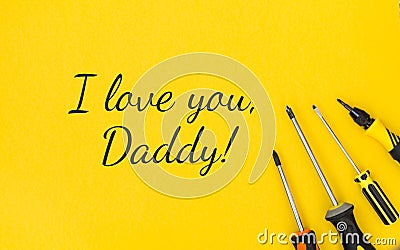 Lucky inscription I love you, Daddy with work tools on a yellow background. Congratulations and gifts. View from above. Father`s Stock Photo