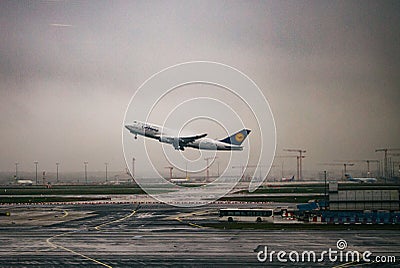 Lufthansa plane taking off from the Frankfurt airport under a gloomy sky on a rainy day in Germany Editorial Stock Photo