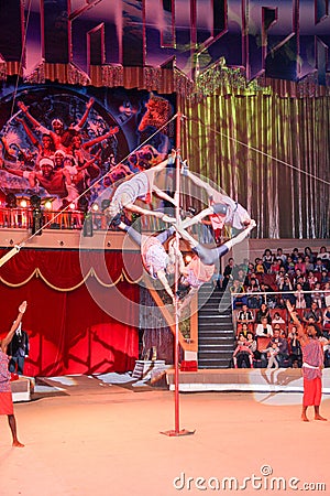 LUGANSK ,UKRAINE - APRIL 9, 2016: several acrobats in a circus performance on the pole Editorial Stock Photo