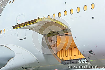 Luggage compartment with open door in wide-body long-haul aircraft Stock Photo