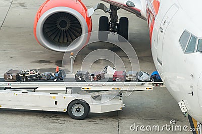 Luggage loading into a plane in an airport Stock Photo