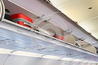 Luggage overhead compartment with hand-luggage in airplane or aircraft cabin interior Stock Photo