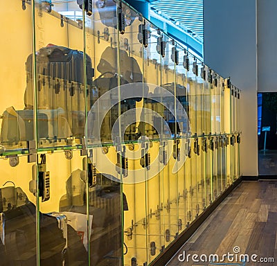 Luggage stored in transparent glass boxes in airport lounge Stock Photo