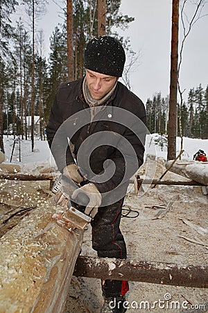 Lumberjack uses the jack-plane to remove bark from logs. Editorial Stock Photo