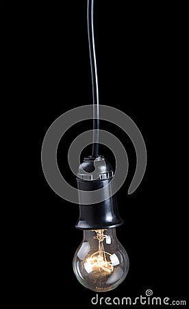 Luminescent electric lamp in receptacle on black Stock Photo