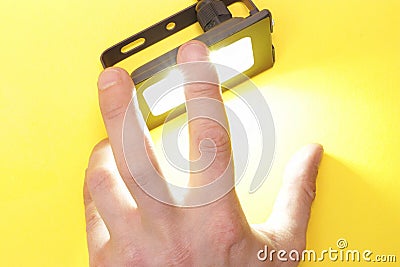 Luminous diode floodlight that holds a male hand. Lighting device. Modern energy-saving technologies. Copy space for text Stock Photo