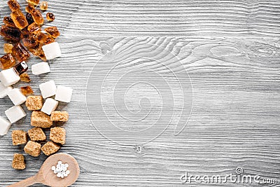 Lumps of sugar in spoons on gray table background top view space for text Stock Photo