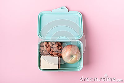 Lunch box with apple, sandwich and almond on pink background Back to school concept with copy space for text Stock Photo