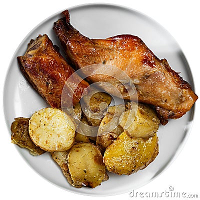 Lunch is served on plate - pieces of young rabbit baked with slice of potato. Close-up Stock Photo
