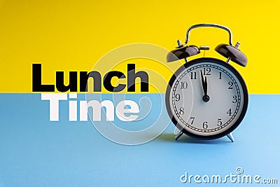 LUNCH TIME inscription written on Alarm Clock on blue yellow background Stock Photo