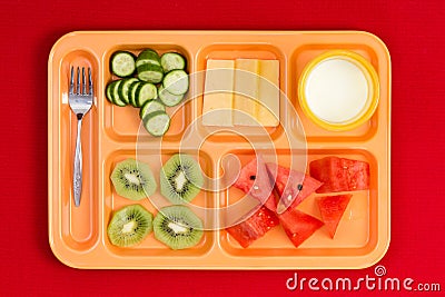 Lunch tray with fork, fruit, cheese and milk Stock Photo