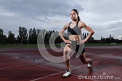 Lunge exercise for quadriceps by athlete on track Stock Photo